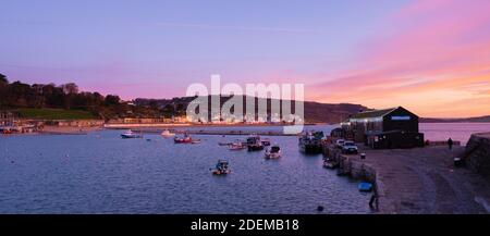 Lyme Regis, Dorset, Großbritannien. Dezember 2020. UK Wetter: Wunderschöne Morgenfarben über dem historischen Cobb, da der Dezember zu einem kalten und winterlichen Start ausbricht. Die Weihnachtslichter entlang der Cobb funkeln hell, während die Weihnachtszeit beginnt. Kredit: Celia McMahon/Alamy Live Nachrichten Stockfoto