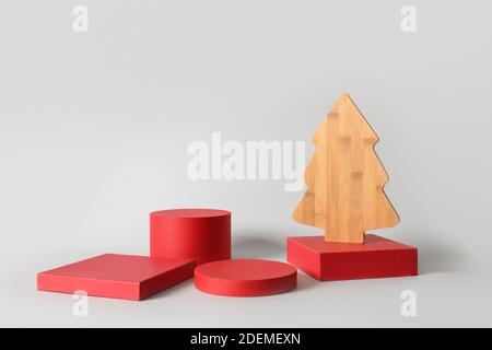 Rote Ständer und dekorative Holz kreativen Weihnachtsbaum. Moderne Podium Hintergrund. Stockfoto