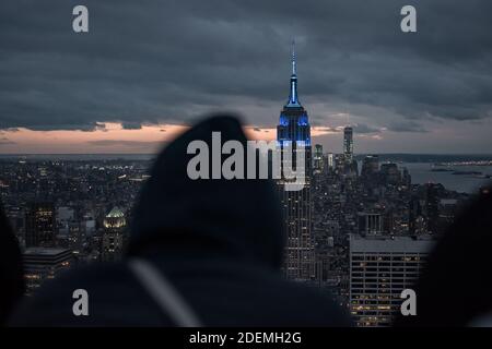 Ein Mann in einem Hoodie schaut auf das Gebäude Stockfoto