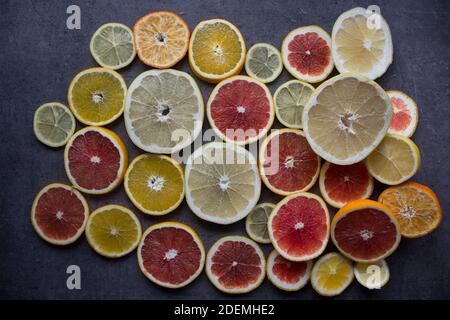 Rot-orange Scheiben auf einem Tisch. Nahaufnahme mit Fruchtstruktur. Dunkelgrauer Hintergrund mit Kopierbereich. Stockfoto