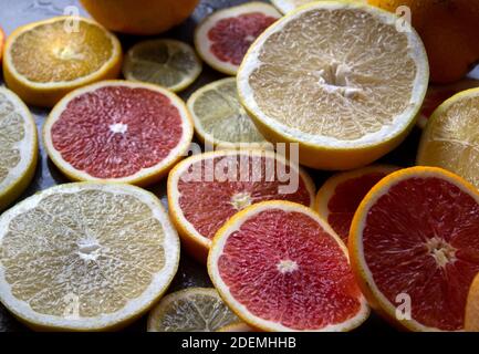 Rot orange Fruchtkreise auf dunkelgrauem Hintergrund. Nahaufnahme mit Zitrusstruktur. Juicy Orangen Draufsicht Foto. Stockfoto