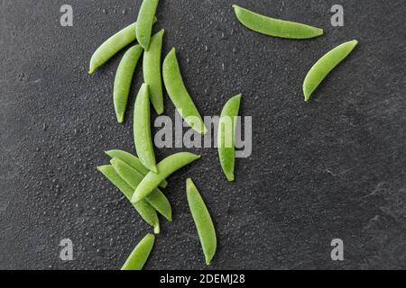 Erbsen auf nassem Schieferstein Hintergrund Stockfoto