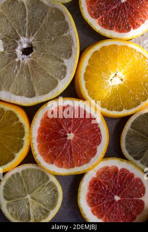 Rot orange Fruchtkreise auf dunkelgrauem Hintergrund. Nahaufnahme mit Zitrusstruktur. Juicy Orangen Draufsicht Foto. Stockfoto