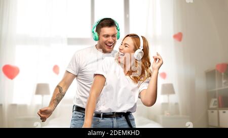 Glückliches Paar in Kopfhörern tanzen Stockfoto