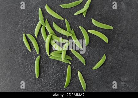 Erbsen auf nassem Schieferstein Hintergrund Stockfoto