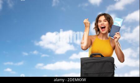 Glückliche junge Frau mit Flugticket und Reisetasche Stockfoto