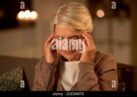Unglückliche ältere Frau, die an Kopfschmerzen leidet Stockfoto