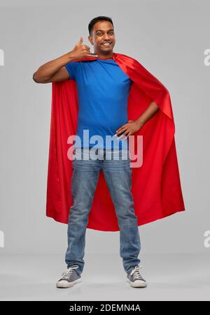 indischer Mann in Superhelden Umhang machen Anruf Geste Stockfoto
