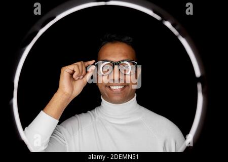 Mann in Gläsern über weißer Beleuchtung auf schwarz Stockfoto