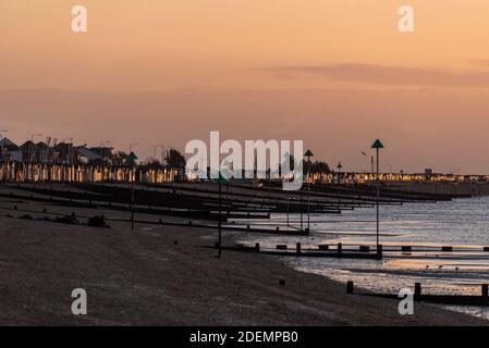 Sonneneinstrahlung Reihe von Strandhütten bei Sonnenaufgang, Sonnenaufgang am ersten Tag des meteorologischen Winters, Dezember 2020 in Southend on Sea, Essex, UK. Reihe von Hütten Stockfoto