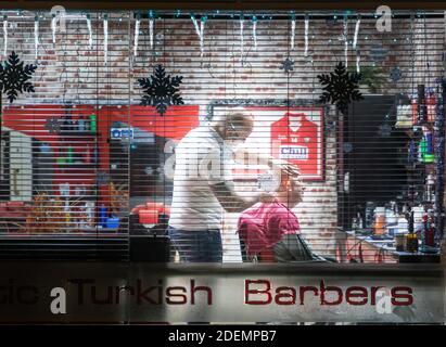 Cork City, Cork, Irland. Dezember 2020. Am ersten Tag der Aufhebung der Level-5-Beschränkungen gibt Barber Hasan Kilic Brad O'Donoghue eine Kopfrasur im Karizma Turkish Barbers in der Oliver Plunkett Street in Cork, Irland. - Credit; David Creedon / Alamy Live News Stockfoto