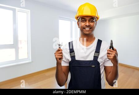 indischer Baumeister im Helm mit Schraubenschlüssel und Zange Stockfoto