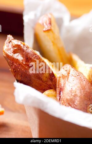 Ethisch angehobener Schweinefleischburger mit handgeschnittenen roten Kartoffelkeilen Und Gemüsestöcke nehmen Stock Foto Stockfoto