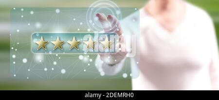 Frau, die ein Konzept für eine Kundenbewertung auf einem Touchscreen berührt Mit den Fingern Stockfoto