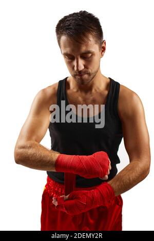 Kämpfer Mann wickelt seine Hände in roten Sportbandagen für das Training. Stockfoto