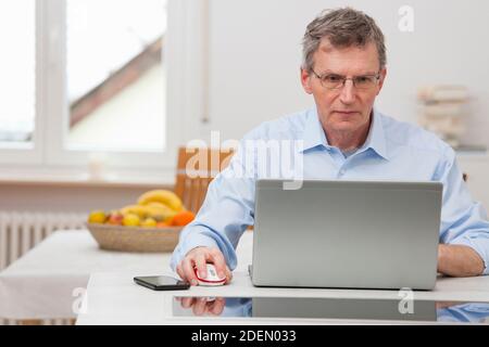 Reife Geschäftsleute arbeiten Remote mit Laptop zu Hause - Fokus Auf dem Gesicht Stockfoto