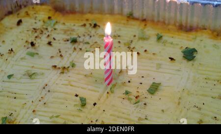 Eine glühende Geburtstagskerze auf einem Schäferkuchen. Stockfoto