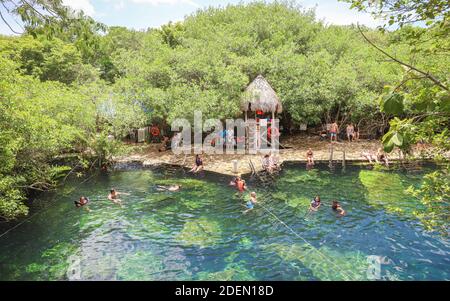 TULUM, MEXIKO - 29. Jul 2019: Ein Rettungsschwimmer wacht über Teenager-Schwimmer im klaren Wasser von Cenote Cristalino entlang der mexikanischen Karibikküste. Stockfoto