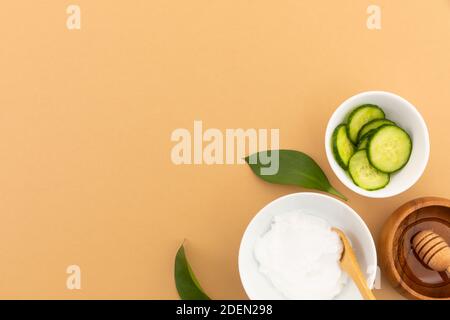 Schüsseln mit Joghurt, Gurke und Dressing auf gelbem Hintergrund Stockfoto