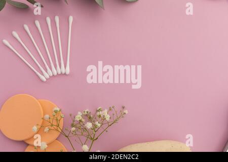 Baumwollknospen und Baumwollpads und Pflanzen auf rosa Hintergrund Stockfoto
