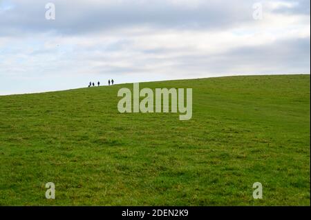 Sechs Wanderer haben auf einem Grat des South Downs Way in der Devil's Dike Area, West Sussex, England, eine Silhouette gemacht. Stockfoto