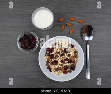 Gesunde Mischung aus Müsli mit Cranberries in Bowl Top View Schwarzer Tisch Stockfoto