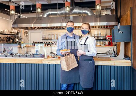 Food Delivery Service Konzept aufgrund covid-19 Lockdown Notfall mit Restaurantbesitzer, die Essen zum Mitnehmen servieren Stockfoto