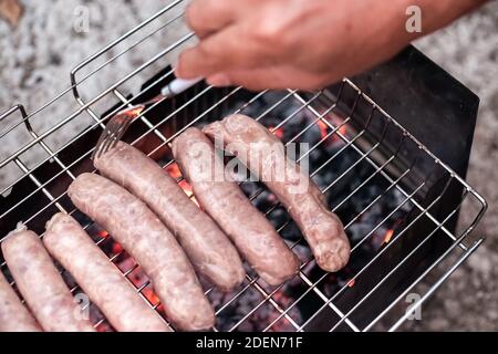 Die Grillwürste liegen auf dem Drahtgitter über dem Grill. Köstliche Fleischdelikatesse. Oktoberfest. Stockfoto