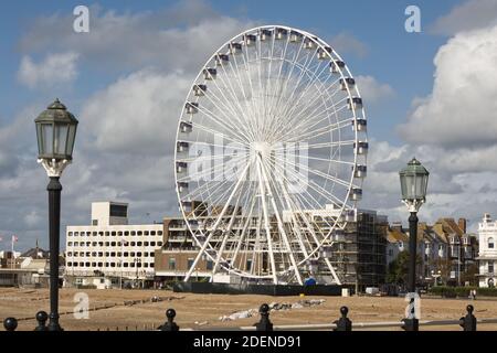 Strandpromenade und Strand in Worthing, West Sussex, England. Mit Riesenrad vom Pier aus gesehen. Stockfoto