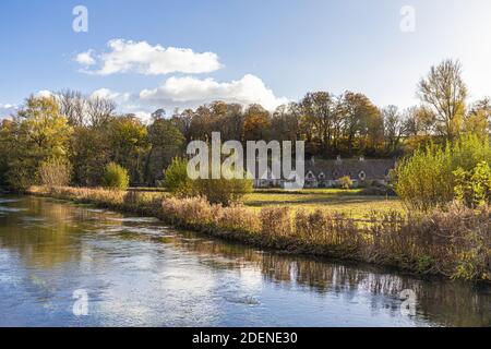 Herbst in den Cotswolds - The River Coln, Rack Isle und Arlington Row im Dorf Bibury, Gloucestershire UK Stockfoto