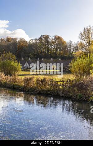 Herbst in den Cotswolds - The River Coln, Rack Isle und Arlington Row im Dorf Bibury, Gloucestershire UK Stockfoto