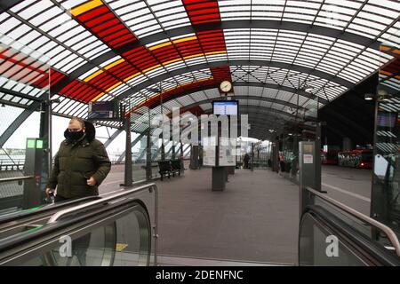Ein Mann mit Schutzmaske EIN Mann geht am 1. Dezember 2020 in Amsterdam, Niederlande, zur Rolltreppe an einer leeren Bushaltestelle inmitten des Coronavirus. T Stockfoto