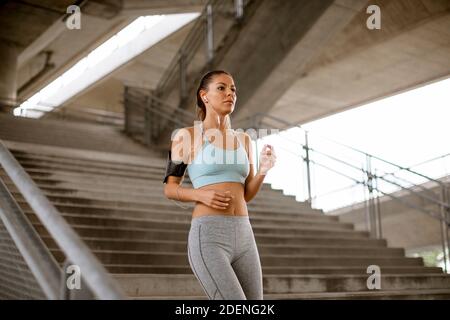 Hübsche junge Frau läuft die Treppe hinunter in der Stadt Umwelt Stockfoto