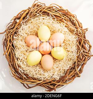 Ländliche Osterzusammensetzung mit bunten Eiern im Nest Stockfoto