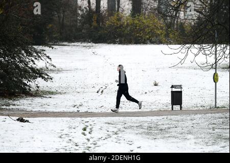 Frankfurt, Deutschland. Dezember 2020. Ein Mann läuft am 1. Dezember 2020 auf einem verschneiten Weg in einem Park in Frankfurt. Quelle: Lu Yang/Xinhua/Alamy Live News Stockfoto