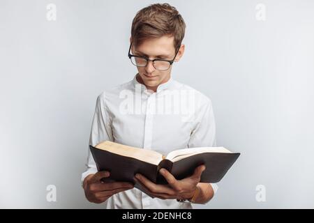 Mann, der Bibel liest, weißer Hintergrund, Buch in der Hand Nahaufnahme, isoliert Stockfoto