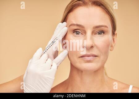 Anti-Aging-Verfahren. Schöne reife Frau erhalten Hyaluronsäure Injektion von Kosmetikerin Stockfoto