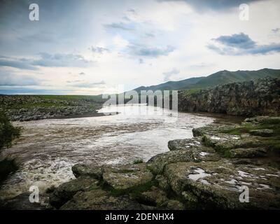 Wilder Fluss in der mongolei. Orchon Region mit Felsen und Bergen im Hintergrund. Stockfoto