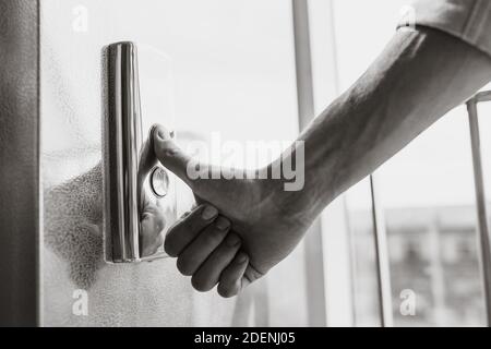 Der Daumen drückt die Elevator-Taste, eine Hand, die nach der Taste greift, das Mädchen wartet auf Elevator, Drucktaste Start, isoliert Stockfoto
