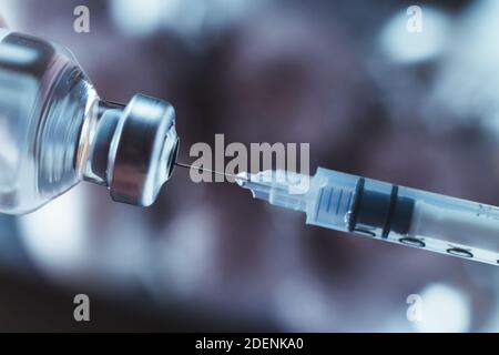 Spritze zieht den Impfstoff aus der Ampulle. Coronavirus und Grippe heilen. Nahaufnahme. Stockfoto