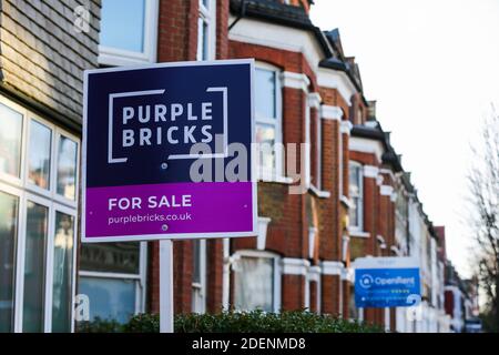 Ein Schild von Purple Bricks ÔFor Sale', das vor einem Grundstück in London aufgestellt wurde. Stockfoto