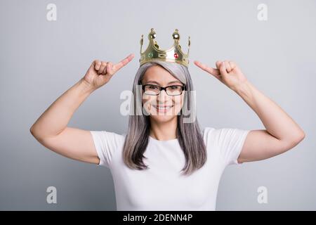 Foto von wunderschönen lustigen alten Frau gekleidet Casual Outfit Brillen Zeigt zeigen zwei Finger Krone isoliert grauen Hintergrund Stockfoto