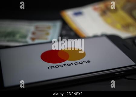 Viersen, Deutschland - 9. April. 2020: Nahaufnahme des Handybildschirms mit Logo-Schriftzug des masterpass Payment Providers auf Computertastatur, verschwommen uns Stockfoto