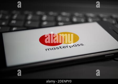 Viersen, Deutschland - 9. April. 2020: Nahaufnahme des Handybildschirms mit Logo-Schriftzug des masterpass Payment Providers auf Computertastatur, verschwommen uns Stockfoto
