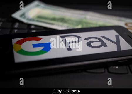Viersen, Deutschland - 9. April. 2020: Nahaufnahme des Handybildschirms mit Logo-Schriftzug von Google Pay Payment Provider auf Computer-Tastatur, verschwommen uns Stockfoto
