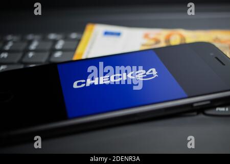 Viersen, Deutschland - 9. April. 2020: Nahaufnahme des Handybildschirms mit Logo-Schriftzug des Check24 Vergleichsportals auf Computertastatur, 50 Euro Geld Stockfoto