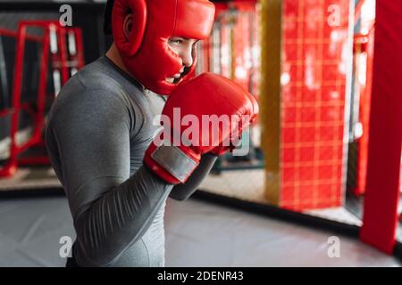 Männliche Boxer in der Ausbildung in der Turnhalle, in einem Käfig für einen Kampf ohne Regeln Stockfoto