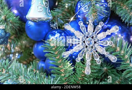 Glas Weihnachten Schneeflocke auf dem Hintergrund der dunkelblauen Weihnachtskugeln. Stockfoto