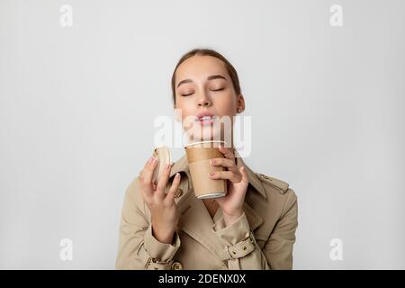 Junge Schönheit Frau genießen Kaffee Heißgetränk aus Einweg recyclebar umweltfreundliche Tasse. Studio-Nahaufnahme im Hochformat Stockfoto