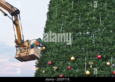 Arbeiter schmücken Weihnachtsbaum auf dem Stadtplatz Stockfoto